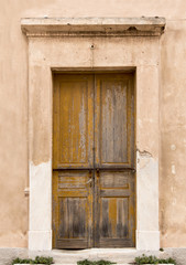 Fototapeta na wymiar Old wooden door on grunge weathered wall.
