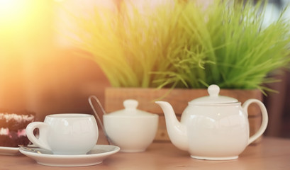 Kettle with a drink and dessert in a street cafe. Tea in the ket