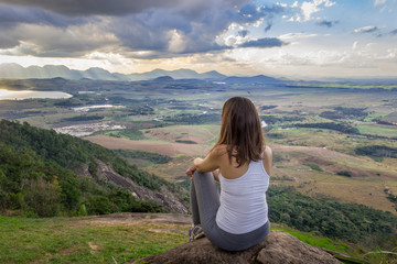 Naklejka premium woman sitting on top of mountain