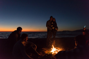 Friends having fun at beach on autumn day