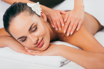 Obraz na płótnie Canvas relaxing woman having massage therapy at spa salon