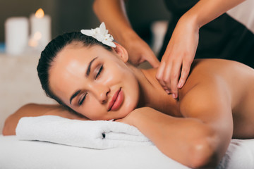 Obraz na płótnie Canvas relaxing woman having massage at spa center