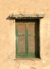 Fototapeta na wymiar Old wooden window on grunge weathered wall.