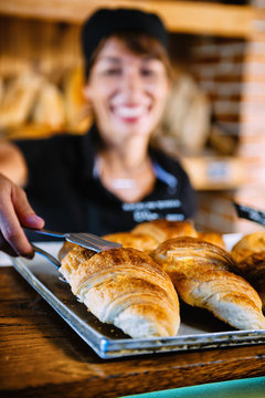 Female Shop Assistant Selling Croissant