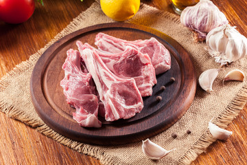 Raw fresh lamb chops on wooden cutting board