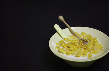 Corn flakes in a plate. Breakfast from flakes with honey and mil