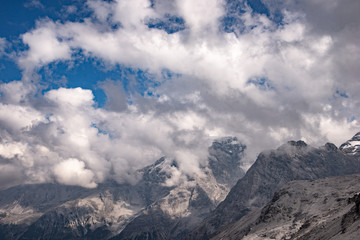 Cime di montagne  nel cielo azzurro con nuvole bianche