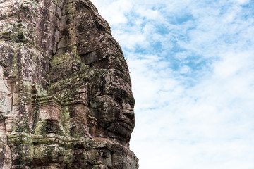 Face carved into stone of the ancient Bayan Temple at Angkor Wat, Cambodia.