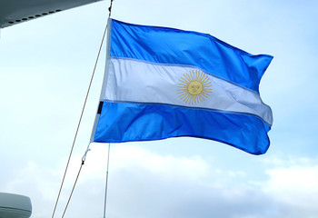 The flag of Argentina on a cruise ship waving against light blue sky 