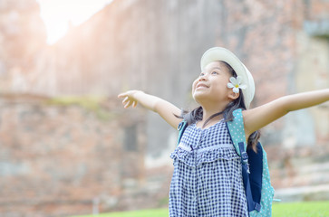 Naklejka premium Portrait of an excited girl raising arms and laughing