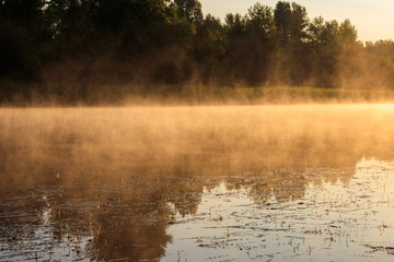 View of river in the mist at sunrise. Fog over river at morning