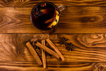 Cup of mulled wine with cinnamon on wooden table. Top view