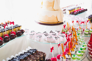Delicious sweets on wedding candy buffet with desserts, cupcakes