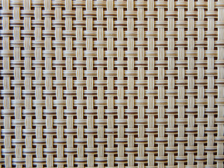 close-up of beige fabric plastic lattice, grid texture; pattern of horizontal and vertical interwoven lines may be used as a background 
