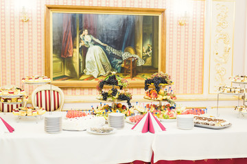 Delicious and tasty dessert table with cupcakes shots at reception closeup
