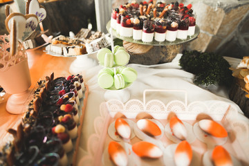 Delicious sweets on wedding candy buffet with desserts, cupcakes