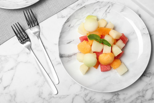 Salad with watermelon and melon on marble background, flat lay