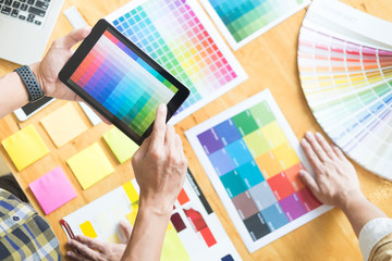 Creative Graphic designer at work. Color swatch samples pantone palette in studio modern office, interior design, renovation and technology concept.