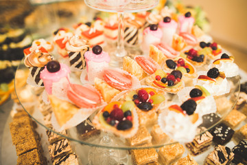 Delicious sweets on wedding candy buffet with desserts, cupcakes