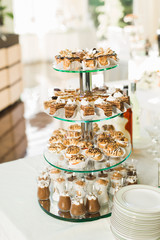 Delicious sweets on wedding candy buffet with desserts, cupcakes