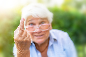 the old woman shows her middle finger. provocation disobedience attitude and offensive rude...