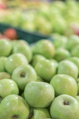 Green apples in a box in the store. green apples in boxes on market shelves. grocery shopping concept. healthy food. vertical photo