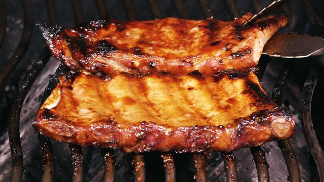 UHD closeup shot of marinated spare ribs roasting on a barbecue grill