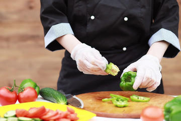 The cook cuts fresh farm vegetables