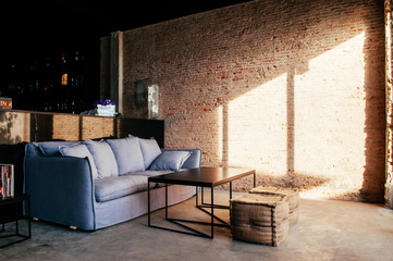 Bangkok old loft brick wall bar with couch and zack stool, natural evening light