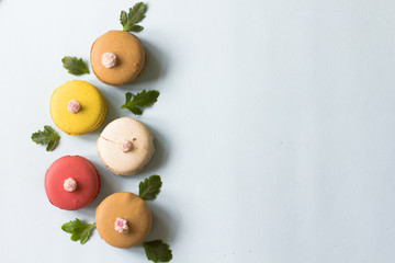 Colorful french macaroons on the blue table flat lay