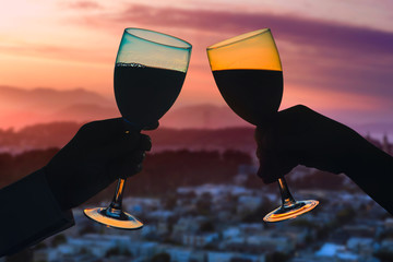 Hands of female's and male's with glass of wine on San Francisco city background. Service on the...