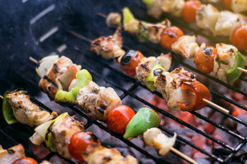 Fresh Vegetables And Marinated Meat On Bamboo Sticks On Barbecue Grill With Fire And Smoking Closeup