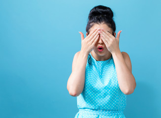 Young woman covering her eyes with her hands