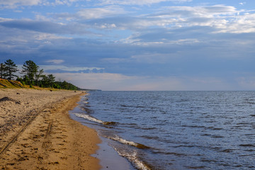 Landscape, sunset on the lake with smooth clouds