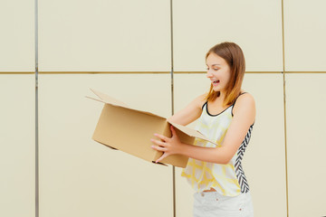 Cheerful young woman opening a cardboard box