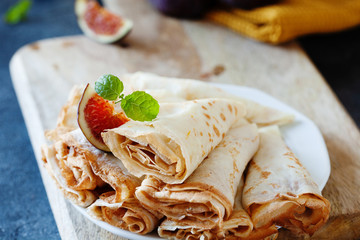 Homemade golden crepes with fresh figs on the plate