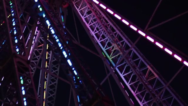Close up ferris wheel moving abstract night time