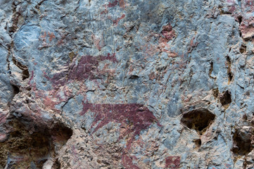 Color prints on the cliff walls, which are ancient prints of people in the past, by this image is called The Cliff of the Mountain Goat, In the tourist attractions of Thailand.