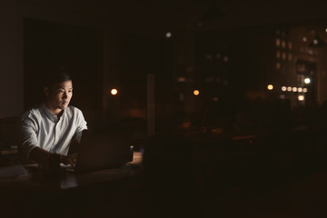 Young Asian businessman working late at night in an office 