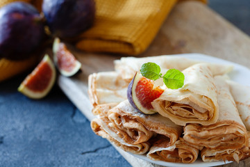 Homemade golden crepes with fresh figs on the plate