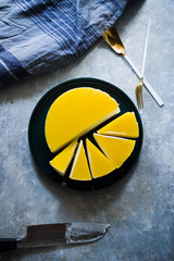 Mascarpone cheese and mangocheesecake over a gray concrete background with kitchen dishes and tools, top view, copyspace left and vertical composition