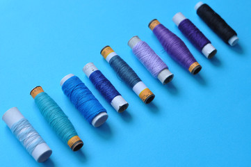 blue thread reels for sewing on a blue background. photo thread on. threads of shades of blue. sewing, needlework, handmade. Use for backgrounds, wallpapers, posters, advertisements, card