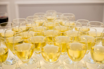 Triangular row of champagne glasses stands on a table with a white tablecloth