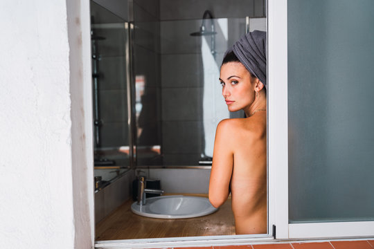Young topless woman standing in bathroom