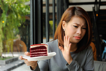 Asian girl refuses cake because she is controlling her calories,Dieting,Cake is heigh calories for...