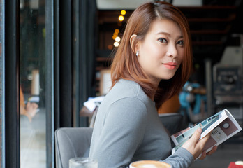 Asian women is enjoying a moment while reading a magazine during a relaxing time