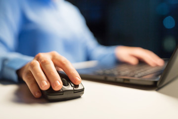 business, education, people and technology concept - close up of female hand with laptop and computer mouse on table