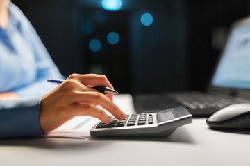 business, finance and accounting concept - close up of businesswoman with calculator counting and...