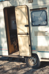 close up of travel trailer with open door in camp