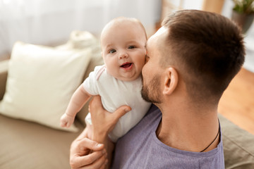 family, parenthood and people concept - close up of father with little baby girl at home